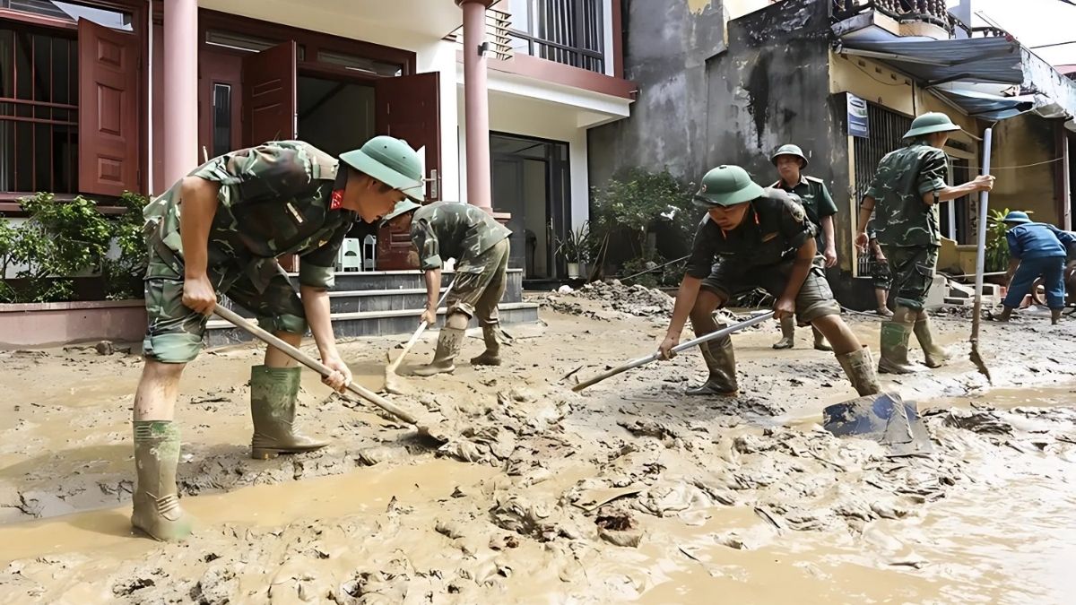 Hình ảnh chú bộ đội đang giúp dân dọn nhà