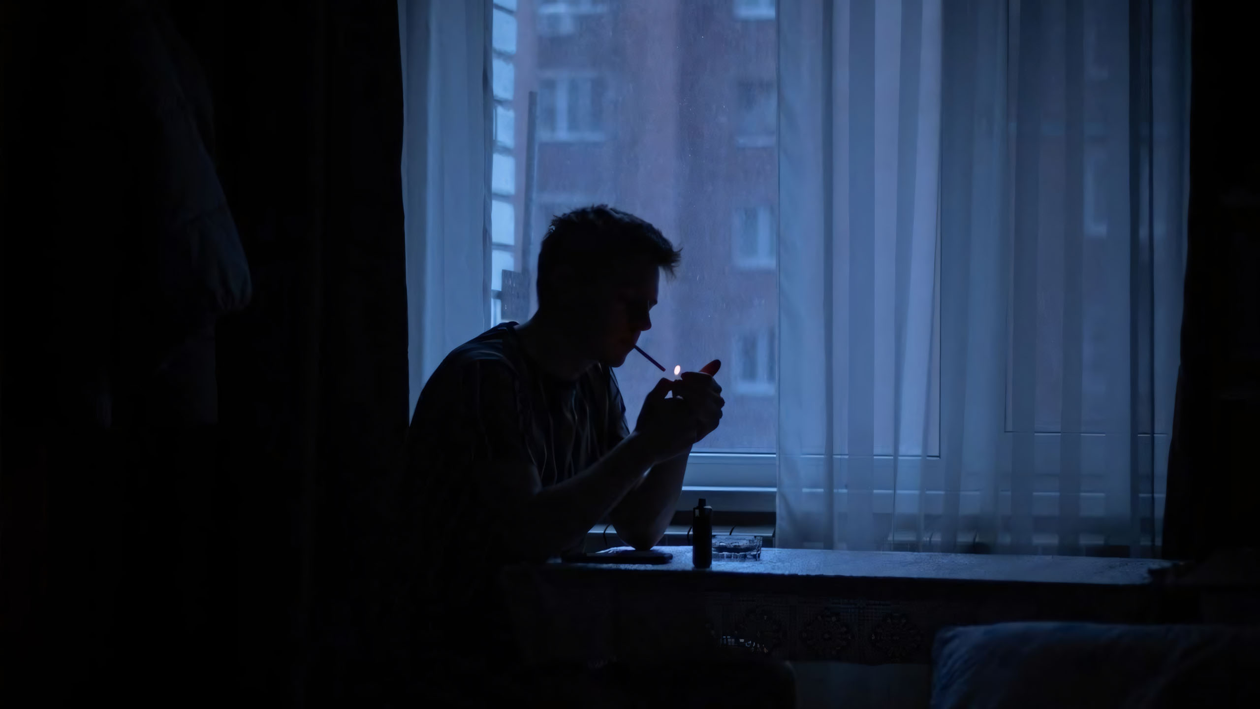 chang trai ben cua so cam dien thoai lang im suy nghi 2560px 1440px 2k