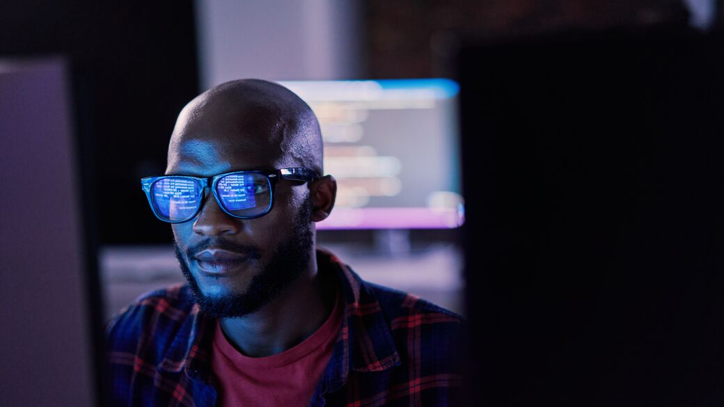 Người đàn ông đang sử dụng máy tính trong môi trường văn phòng