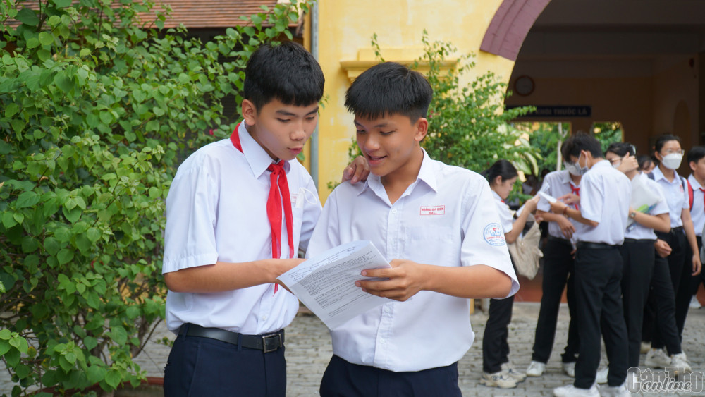 TS trao đổi bài làm sau giờ thi môn tiếng Anh tại Hội đồng coi thi Trường THPT Châu Văn Liêm. Ảnh: B.Ngọc
