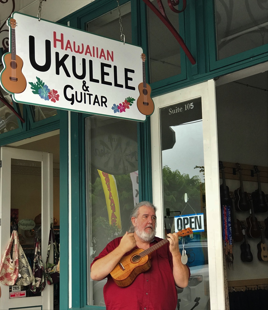 "Uncle Uke" Robert Yates playing ukulele in front of his store, Hawaiian Ukulele & Guitar