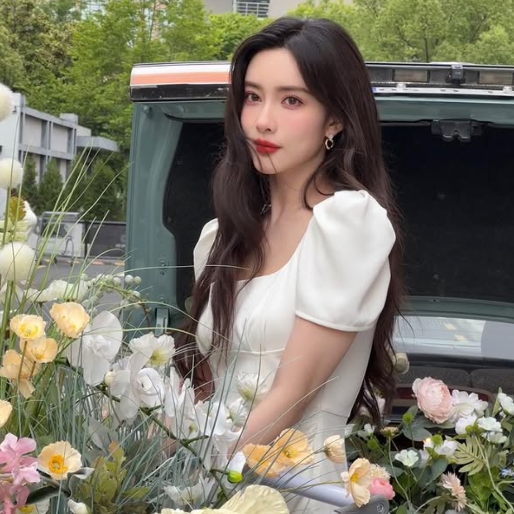 Mạnh Tử Nghĩa mặc đầm trắng đứng cùng những bông hoa.