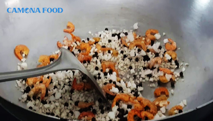 Cho phần tôm đã sơ chế trước đó vào chảo rang cùng muối và tiêu