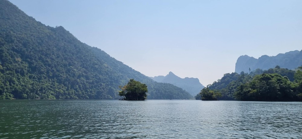 Mặt hồ rộng mênh mông như một tấm gương khổng lồ soi bóng cây, núi rừng nơi đây.